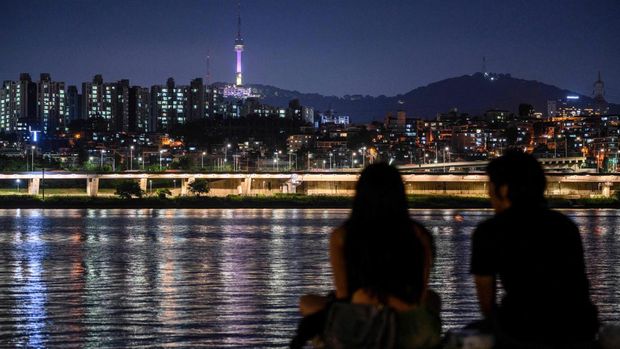 Landmark Namsan Seoul Tower diterangi dengan warna ungu untuk menandai peringatan 10 tahun megabintang K-pop BTS, di Seoul pada 12 Juni 2023. (ANTHONY WALLACE/AFP via Getty Images)
