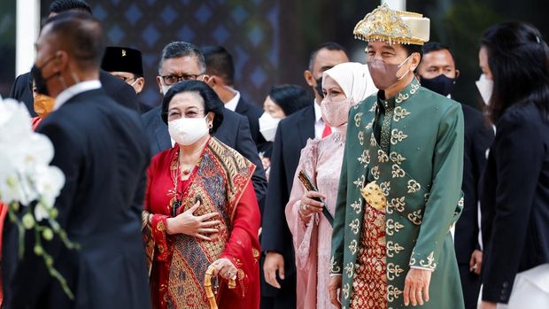 Presiden Indonesia Joko Widodo, mengenakan pakaian adat dari Kepulauan Bangka Belitung, ditemani istrinya Iriana Widodo dan Mantan Presiden Megawati Sukarnoputri, berjalan meninggalkan gedung parlemen setelah menyampaikan kenegaraan tahunan, menjelang Hari Kemerdekaan negara, di Jakarta, Indonesia, 16 Agustus 2022. REUTERS/Willy Kurniawan/Pool