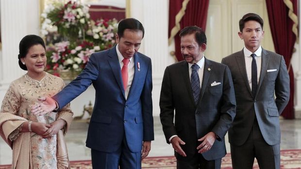 Indonesian President Joko Widodo, second left, directs Brunei's Sultan Hassanal Bolkiah, second right, as Widodo's wife Iriana, left, and Bolkiah's son Abdul Mateen look on during their meeting ahead of Widodo's inauguration, at Merdeka Palace in Jakarta, Indonesia, Sunday, Oct. 20, 2019. (AP Photo/Dita Alangkara)