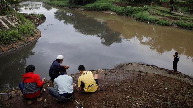 Men fish at a polluted tributary, which runs through an area densely populated with textile factories and where it joins the Citarum river, near Majalaya, south-east of Bandung, West Java province, Indonesia, February 14, 2018. REUTERS/Darren Whiteside  SEARCH 