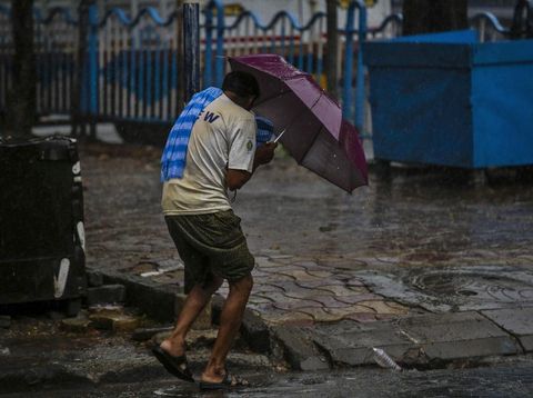A man struggles to hold his umbrella and walk against high wind in Kolkata, India, Wednesday, May 20, 2020. Amphan, a powerful cyclone has slammed ashore along the coastline of India and Bangladesh where more than 2.6 million people fled to shelters in a frantic evacuation made all the more challenging by the coronavirus pandemic. (AP Photo/Bikas Das)