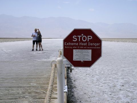 A person walks on a boardwalk at the salt flats at Badwater Basin, Monday, Aug. 17, 2020, in Death Valley National Park, Calif. Death Valley recorded a scorching 130 degrees (54.4 degrees Celsius) Sunday, which if the sensors and other conditions check out, would be the hottest Earth has been in more than 89 years and the third-warmest ever measured. (AP Photo/John Locher)