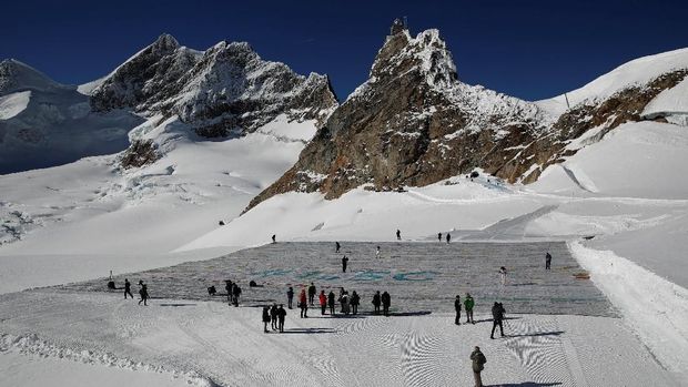 A general view shows 100,000 postcards with messages against climate change, sent by young people from all over the world and stuck together to break the Guinness World Record of the biggest postcard on the Jungfraufirn, the upper part of Europe's longest glacier, the Aletschgletscher, near Jungfraujoch, Switzerland November 16, 2018.   REUTERS/Arnd Wiegmann