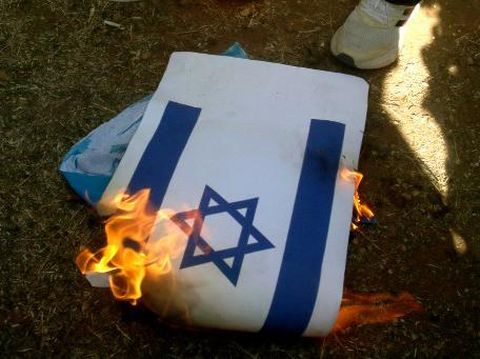 Lebanese and Palestinian students burn a copy of the Israeli flag during a solidarity rally with the Palestinians of the Gaza Strip, in Martyrs' Square in the coastal city of Sidon, in southern Lebanon on October 26, 2023, amid the ongoing battles between Israel and the Palestinian group Hamas. Thousands of civilians, both Palestinians and Israelis, have died since October 7, 2023, after Palestinian Hamas militants based in the Gaza Strip entered southern Israel in an unprecedented attack triggering a war declared by Israel on Hamas with retaliatory bombings on Gaza. (Photo by Mahmoud ZAYYAT / AFP)