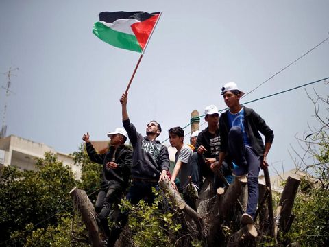 Palestinians climb over a tree during a rally marking International Workers' Day, or Labour Day, in Gaza City May 1, 2019. REUTERS/Mohammed Salem
