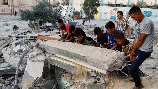 Palestinians remove debris at a mosque destroyed in Israeli strikes in Khan Younis, in the southern Gaza Strip, October 8, 2023. REUTERS/Ibraheem Abu Mustafa