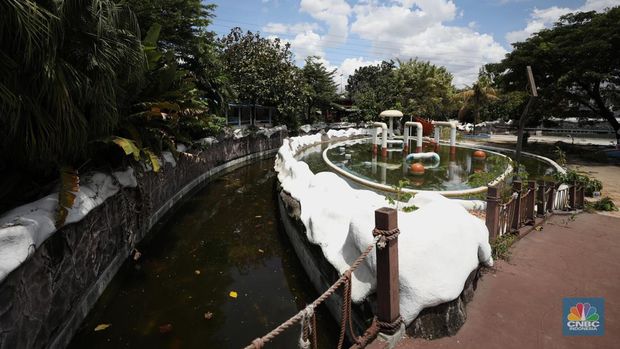 Pekerja melakukan perancangan proyek revitalisasi Taman Mini Indonesia Indah (TMII), Senin (24/1/2022). Snowbay Waterpark dulunya dikenal sebagai wahana favorit anak-anak, sayangnya karena COVID-19, kolam renang dengan berbagai wahana itu harus ditutup selama nyaris 2 tahun. Beberapa kondisi fisik yang terbengkalai terlihat dilokasi ini mulai pintu masuk tiket dan rak tempat penitipan barang. Kondisi Snowbay Waterpark saat ini memang tak terurus karena sudah lama tutup. Sejumlah kolam renang dibiarkan begitu saja hingga airnya keruh. Terlihat juga toko-toko yang dulu menjual perlengkapan renang dan kuliner juga tutup.  
Dikutip dari situs tamanmini.com, Snowbay Waterpark mulanya dirancang secara khusus sebagai taman rekreasi petualangan berkelas dunia berkonsep pegunungan salju
Taman seluas 3 hektar ini dibangun tahun 2008 dan diresmikan pembukaannya oleh ketua Yayasan harapan Kita, Hj. Siti Hardiyanti Rukmana pada tanggal 19 April 2009. Sebelumnya, taman ini adalah Taman Rekreasi Ambar Tirta. (CNBC Indonesia/ Tri Susilo)
